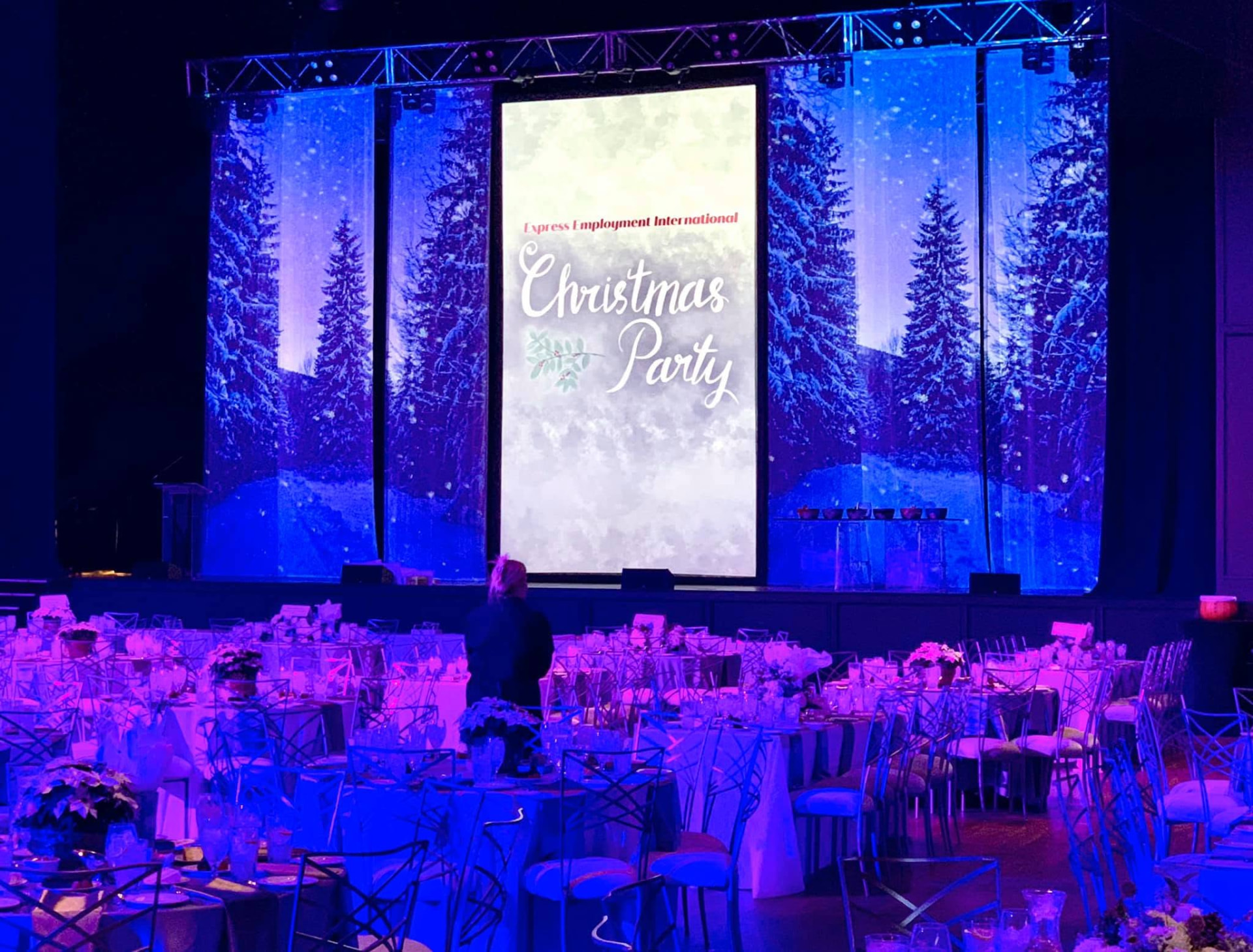 Holiday party with blue winter staging and decorated banquet tables, Bricktown Event Center.