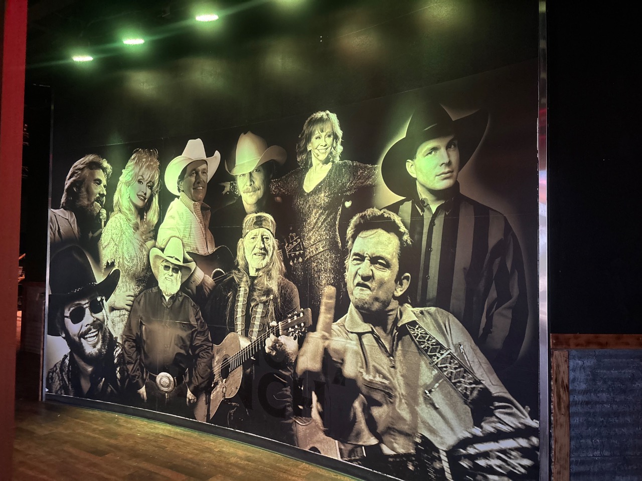 Country music mural on the interior wall lit in green house light, Bricktown Event Center.